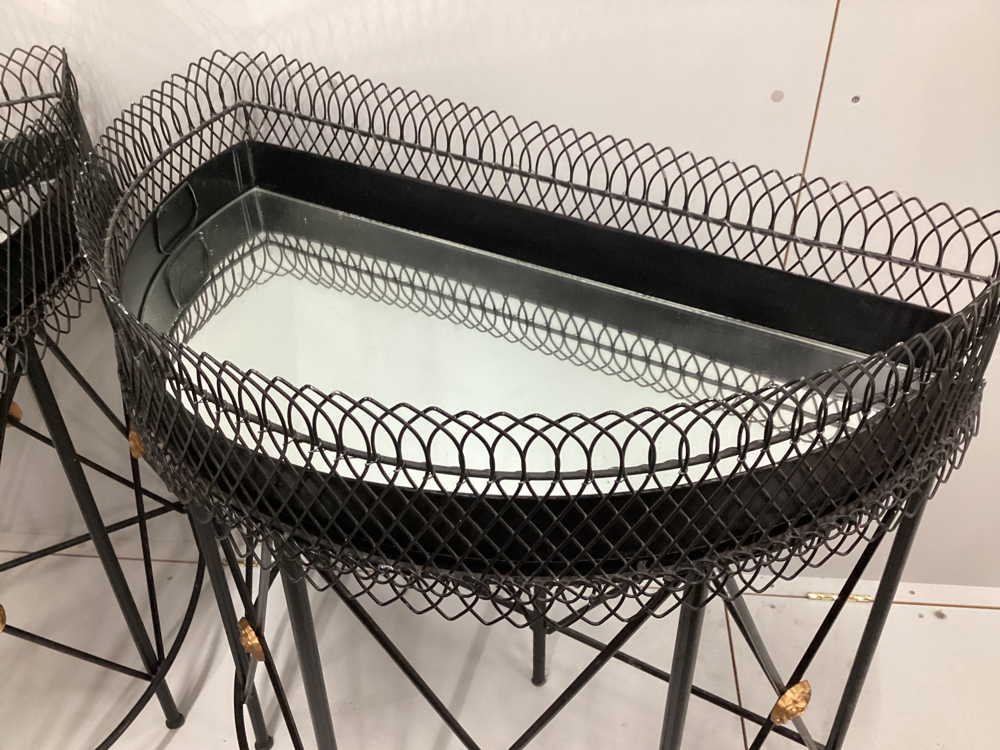 A pair of contemporary wrought iron and wirework 'D' shaped console tables with mirrored tray inserts, width 94cm, depth 52cm, height 94cm